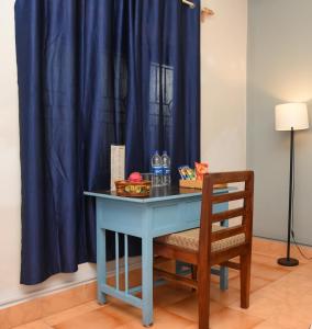 a blue table with a chair in front of a blue curtain at Bens Inn in Mandrem