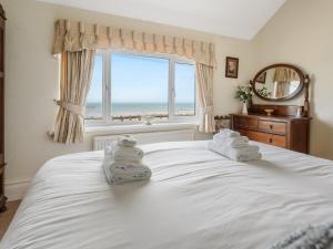 - une chambre avec un grand lit blanc et une fenêtre dans l'établissement Pass the Keys Spacious 4 bed house overlooking Borth Beach, à Borth