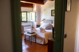 ein Schlafzimmer mit einem Bett und einem Tisch in einem Zimmer in der Unterkunft Masseria Montepaolo Dimora di Charme in Conversano