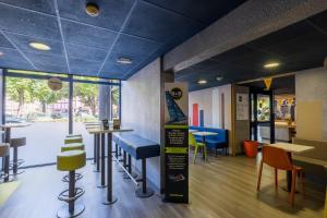 a restaurant with blue ceilings and tables and chairs at B&B HOTEL Troyes Centre in Troyes