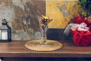 eine Vase mit Blumen auf einem Tisch mit einer Kerze in der Unterkunft Maison ALANA in Divčibare