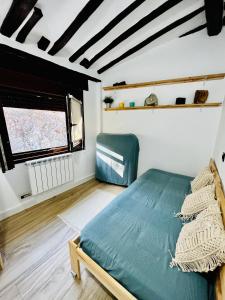 a bedroom with a bed in a room with a window at La casita del rio in Soto en Cameros