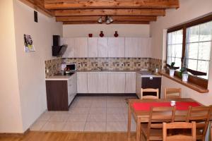 a kitchen with a table and a dining room at Nad Stawem in Powidz