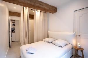 een slaapkamer met een wit bed met 2 kussens bij "L'historique" - Charmant appartement en centre-ville historique in Chambéry