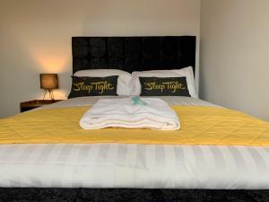 a bed with a yellow blanket and two pillows at The Mancunian @ The Gathering - Sleeps Up To 6 in Sale