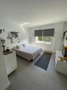 biała sypialnia z łóżkiem i oknem w obiekcie Plaza de toros / Centro w Maladze