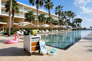 a resort with a pool and a surfboard next to a resort at Family Selection at Grand Palladium Costa Mujeres Resort & Spa - All Inclusive in Cancún