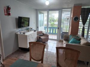 sala de estar con TV y sofá en Playa Azul II 302, en Luquillo