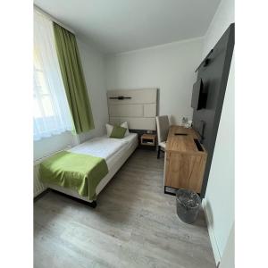 a bedroom with a bed and a desk in it at Hotel und Restaurant Kranichsberg in Woltersdorf