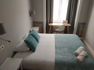 リスボンにあるGreat Stay Fanqueiros Guest House 3のベッドルーム1室(大型ベッド1台、タオル付)