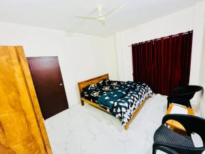 um quarto com uma cama e uma ventoinha de tecto em Darshan Arrive & Revive Homestay. em Kushalanagar