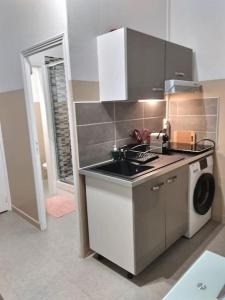 a kitchen with a sink and a washing machine at LE CHARMANT STUDIO 4 FACE GARE *WIFI* in Évreux