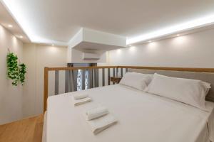 Un dormitorio con una cama blanca con toallas. en FCM Tourism - Rosales Studio, en Milán