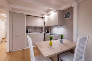 a kitchen with a wooden table and white cabinets at FCM Tourism - Rosales Studio in Milan