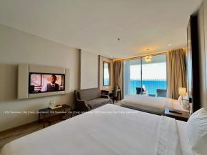 a hotel room with a bed and a tv at Panorama Apartment Nha Trang in Nha Trang