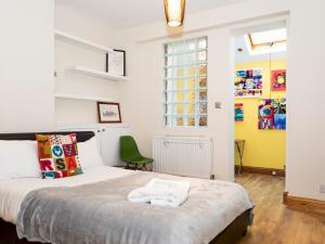 1 dormitorio con 1 cama con 2 toallas en Pass the Keys Funky Garden House in Chiswick, en Londres