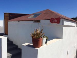een klein wit gebouw met een lachteken erop bij Climbing Suite with sky windows ! in Santa Cruz de Tenerife
