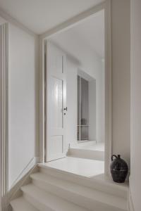 een witte hal met een spiegel aan de muur bij LuxuryApartmentSoulforCity in Gent