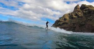 um homem a surfar uma onda numa prancha de surf no oceano em Climbing Suite with sky windows ! em Santa Cruz de Tenerife