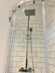 a shower in a bathroom with white tiles at The Islington Studio @ The Gathering - Sleeps Up To 3 in Sale