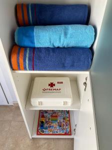 a towel organizer with a box and towels in it at S&H La Malquerida in Formentera del Segura