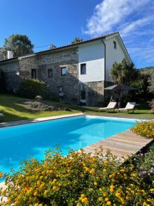 una casa con piscina frente a ella en Villa D’Aurora Country Suites, en Ponte de Lima