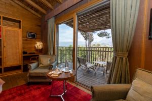 een woonkamer met een balkon met een tafel en stoelen bij La Signoria in Calvi