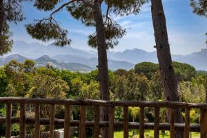- une vue depuis la terrasse d'une maison avec des arbres et des montagnes dans l'établissement La Signoria, à Calvi