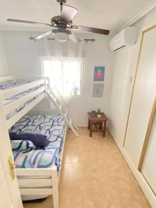 a bedroom with a bunk bed and a ceiling fan at S&H La Malquerida in Formentera del Segura