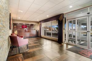 a lobby with a pink chair and large windows at Red Roof Inn Baltimore South Glen Burnie in Glen Burnie