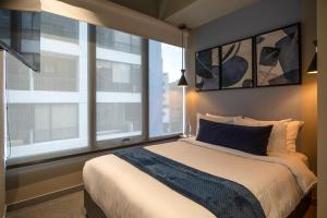 1 dormitorio con cama y ventana grande en Unique Mine - Luxury Lofts with Pool - Gym - Cowork, en Bogotá