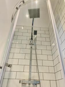 a shower with a hose on a white tiled wall at The Castlefield @ The Gathering - Sleeps Up To 5 in Sale