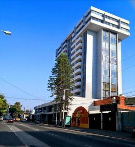 a tall white building on a city street with a road at apartamento 407 zona 9 in Guatemala