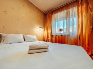 een slaapkamer met een groot wit bed en een raam bij Apartments near the Exhibition Centre in Kiev