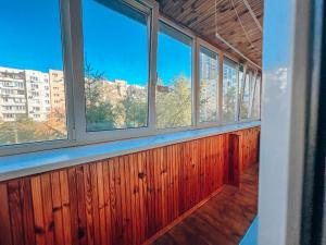 una fila de ventanas en una habitación con paneles de madera en Apartments near the Exhibition Centre en Kiev