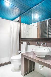 La salle de bains est pourvue d'un lavabo, de toilettes et d'un plafond bleu. dans l'établissement Santorini Villas Santa Marta, à Santa Marta