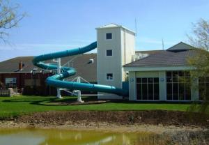 a blue slide in front of a building at Southview Holiday Park Skegness - Upgraded Caravan - Unica in Skegness
