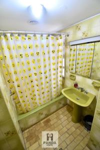 a bathroom with a shower curtain and a sink at Panda Hostel Mendoza in Mendoza