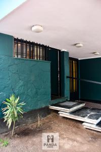 un bâtiment avec un mur vert et quelques fenêtres dans l'établissement Panda Hostel Mendoza, à Mendoza