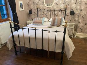 a bedroom with a black bed with white sheets and pillows at Le Moulin des Farges in Meymac