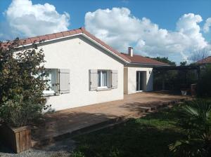 une maison blanche avec une terrasse en bois devant elle dans l'établissement Chambre d'hôte avec Hammam et salle de jeux, à Chazelles-sur-Lyon