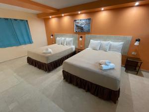2 letti in camera d'albergo con asciugamani di Aqua by Dreams Hotel 