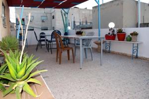 an outdoor patio with a table and chairs and plants at The Blue House "Gerasa" in Jerash