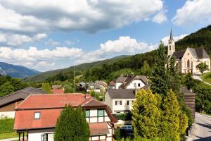 małe miasteczko z kościołem w górach w obiekcie Kaiserhof w mieście Reichenau an der Rax