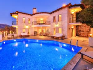 a villa with a swimming pool in front of a house at Villa Mavi Manzara in Kas