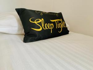 uma almofada preta sentada em cima de uma cama em The Lower Gathering - Sleeps Up To 13 em Sale