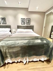 a bedroom with a large bed in a room at Flat novo, 2 quartos, garagem no coração dos Jardins in Sao Paulo