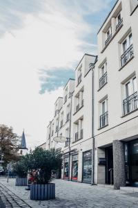 un gran edificio blanco en una calle de la ciudad en Villa Bosco - Digitales Boutiquehotel, en Walldorf