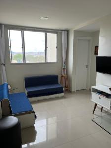 a living room with a blue couch and a tv at Apto 301 in Caruaru +6 photos