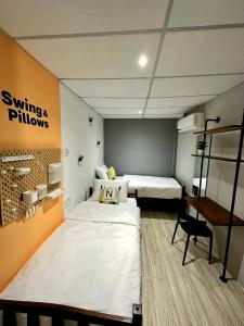 um quarto com duas camas e uma secretária em Swing & Pillows @ Beach Street em George Town